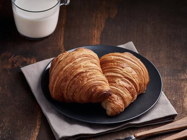 Latte and a croissant on a café table